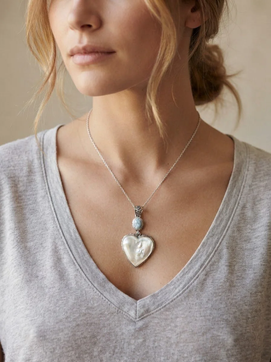 Woman wearing Mother of Pearl heart and Larimar sterling silver statement pendant