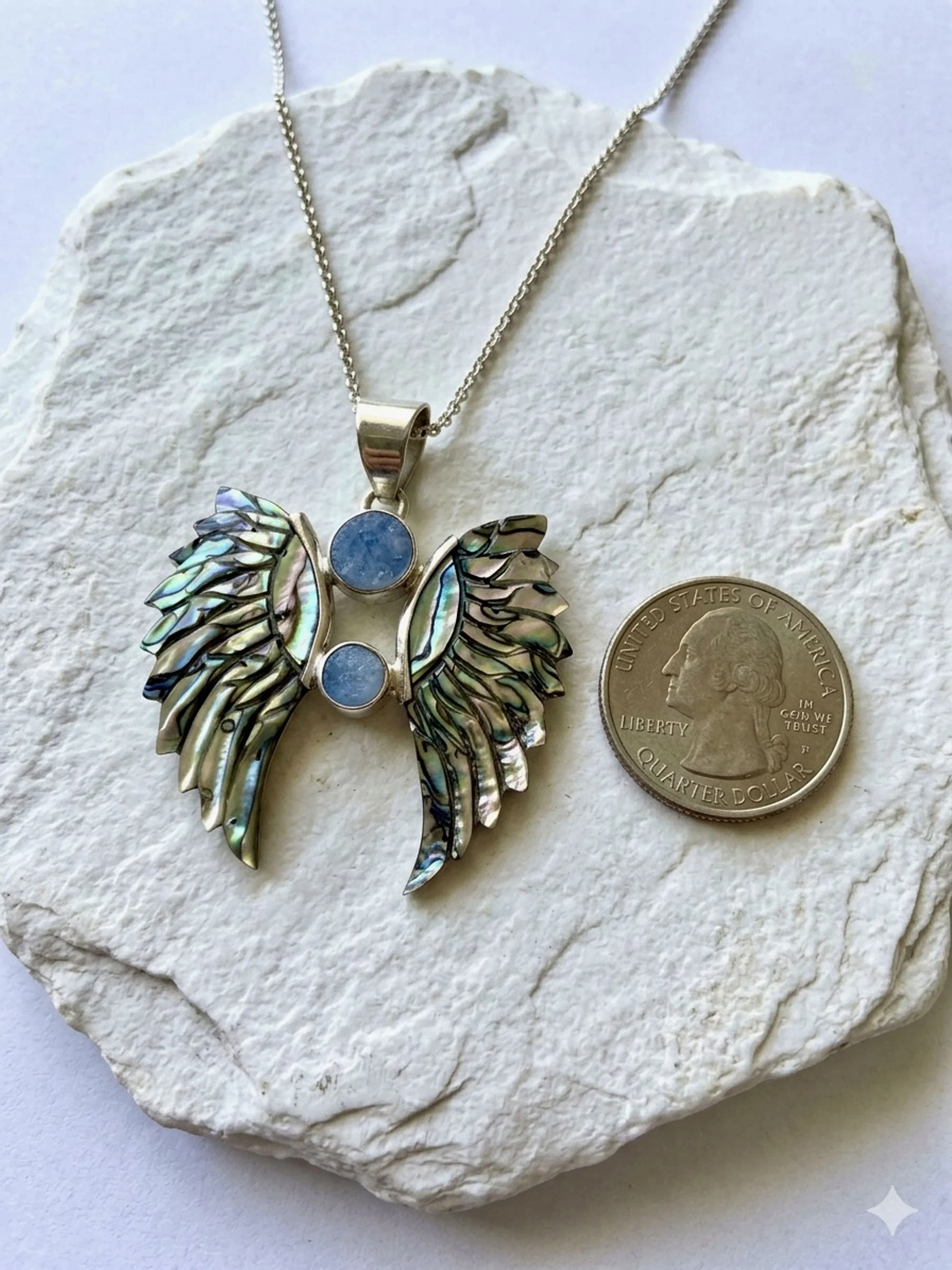 Sterling silver angel wing necklace with natural opal gemstones and abalone shell artisan craftsmanship.