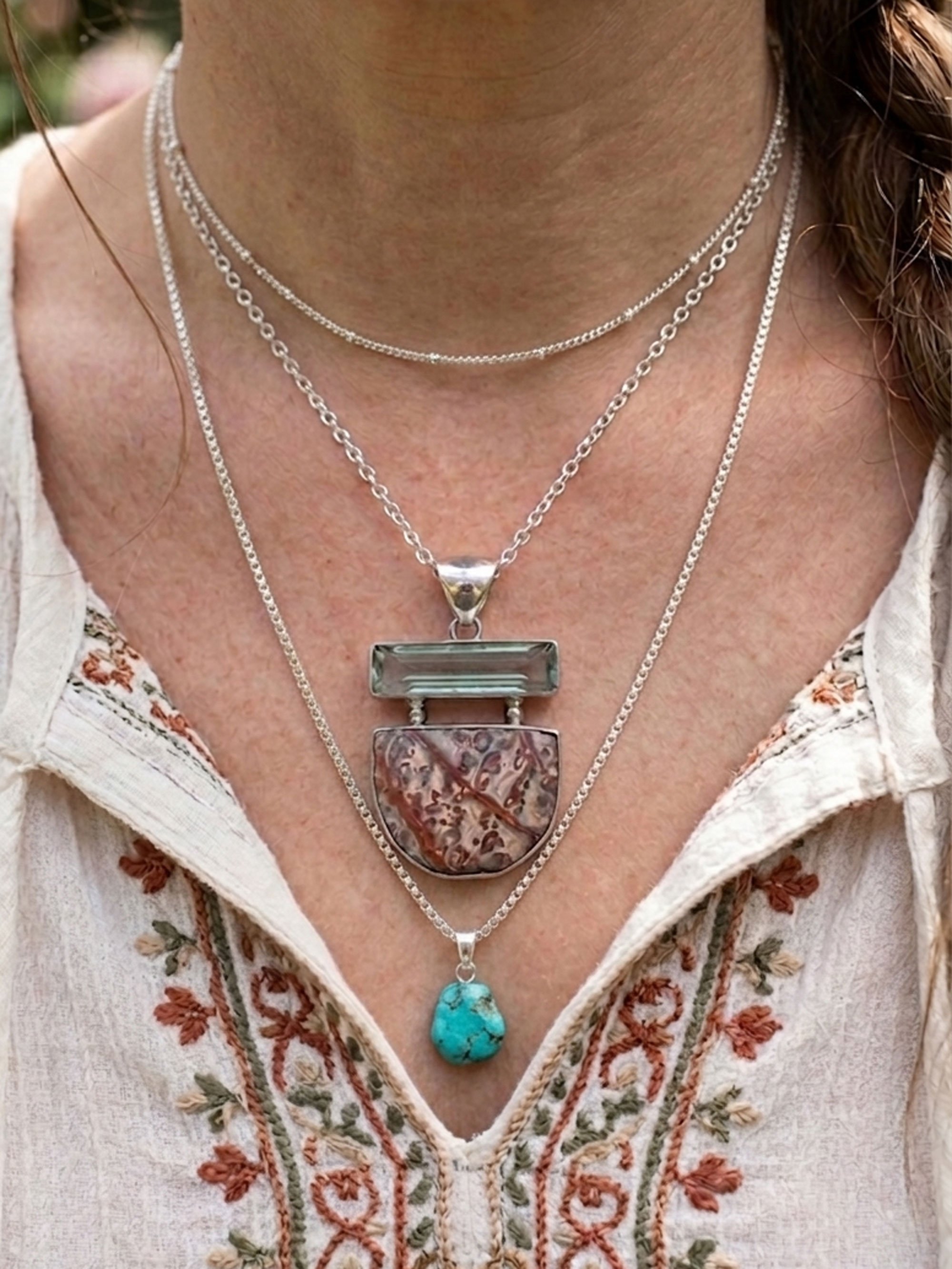 Boho artisan gemstone necklace featuring natural Red Jasper and Blue Obsidian set in sterling silver showing with other chains