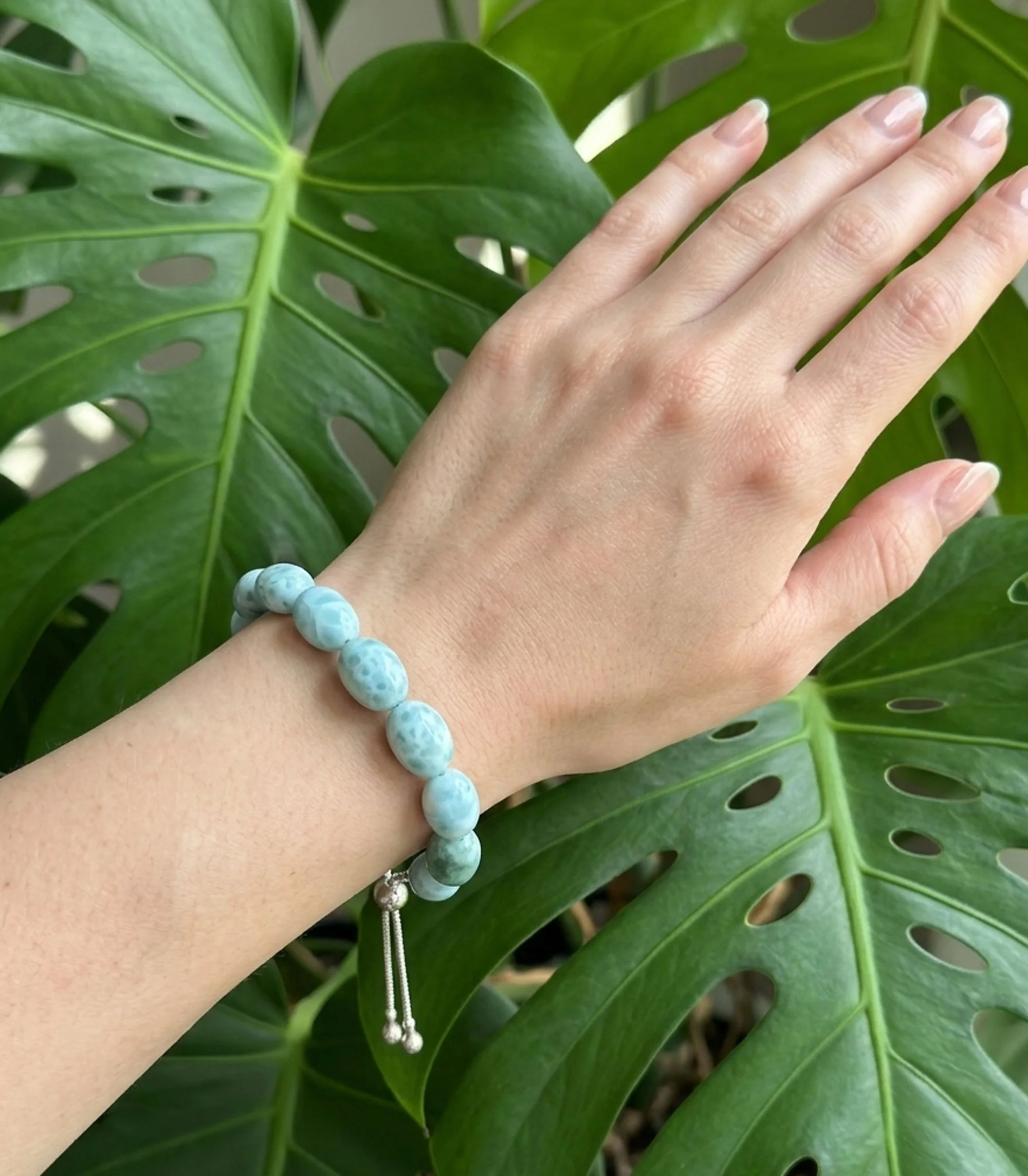 Island Calm Larimar Bracelet worn on wrist with natural larimar gemstone beads and sterling silver adjustable closure