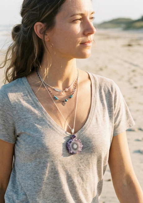Amethyst Stalactite pendant worn on silver chain by model on the beach