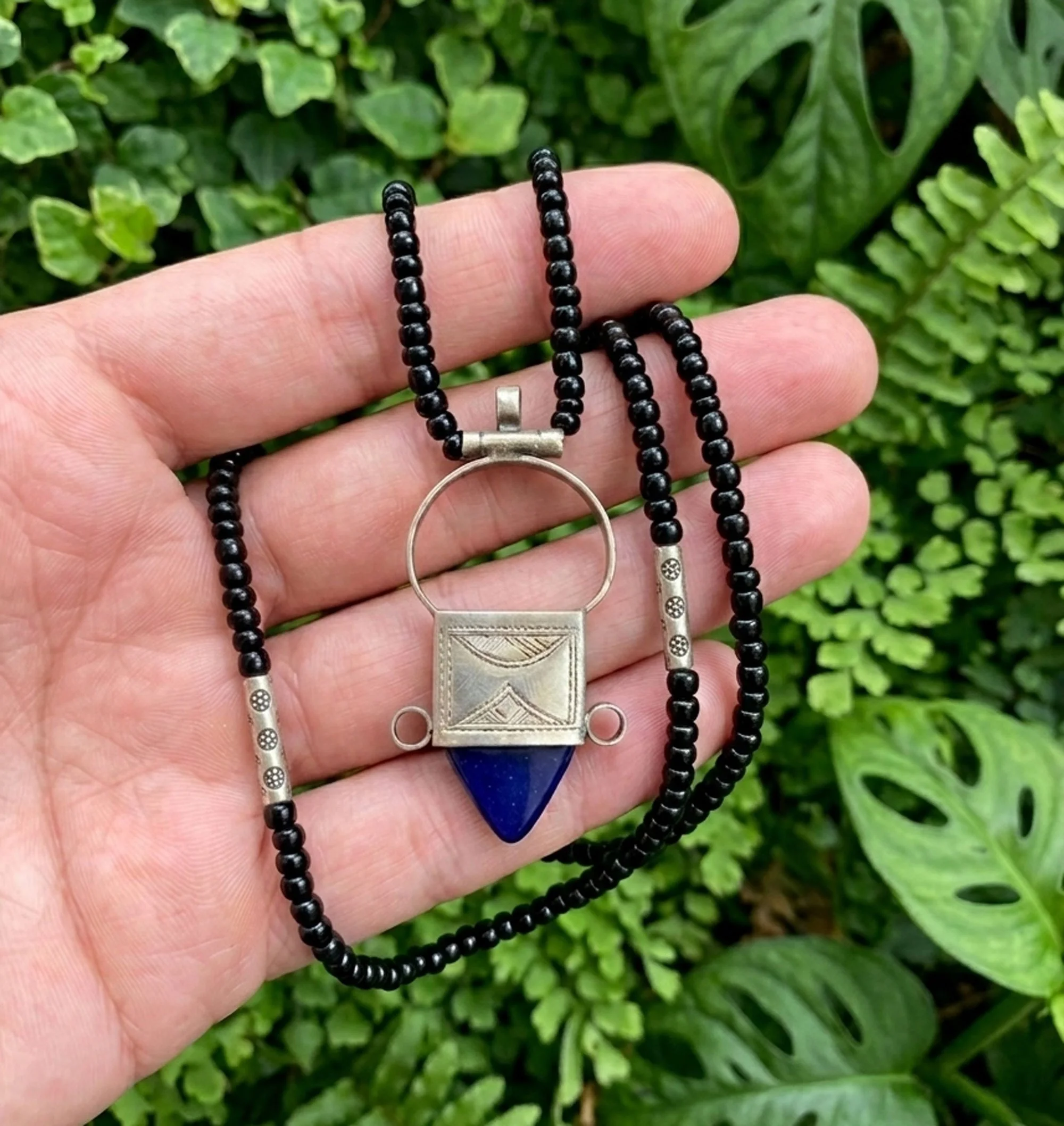 Boho Moroccan necklace with deep blue stone pendant and black beaded chain, handcrafted artisan jewelry.