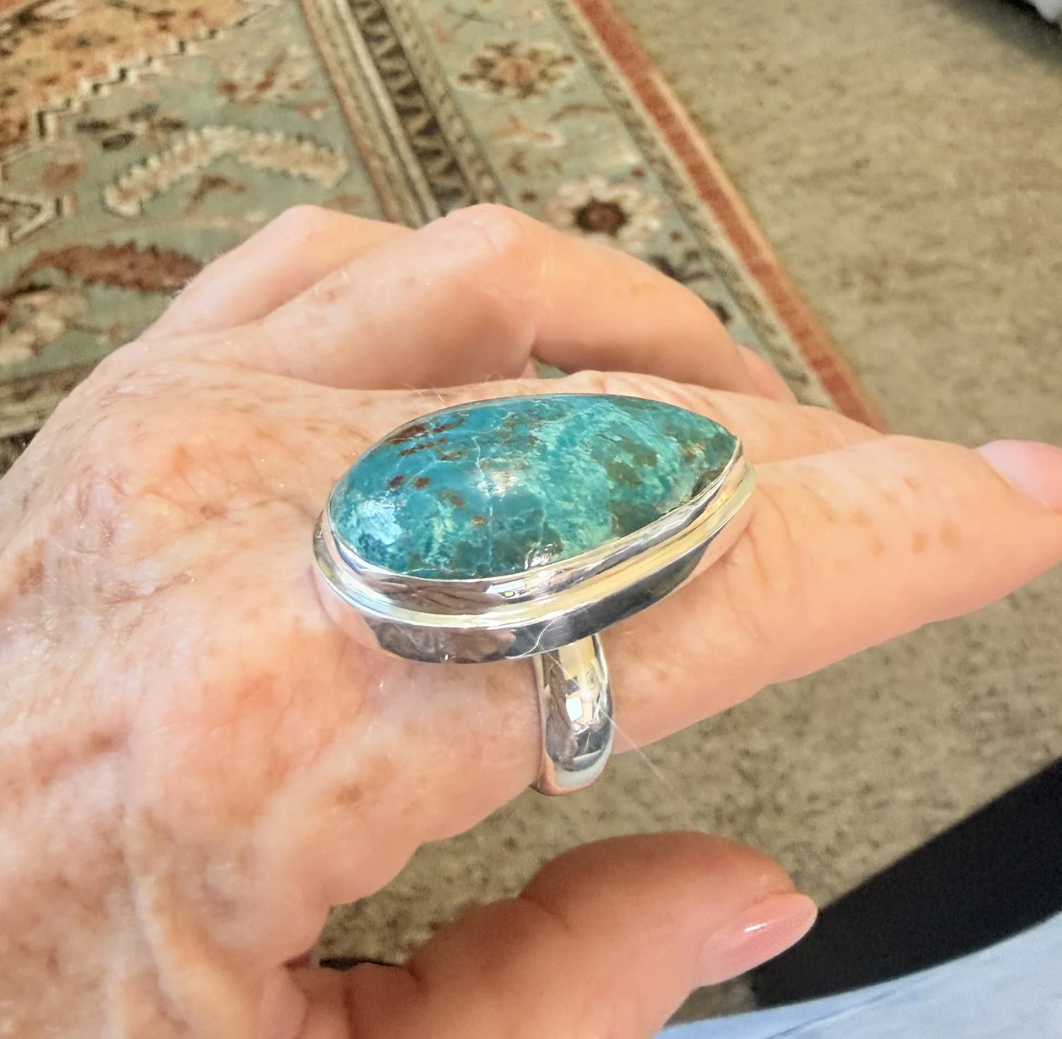 Close-up of natural Chrysocolla sterling silver statement ring with large teardrop blue-green gemstone