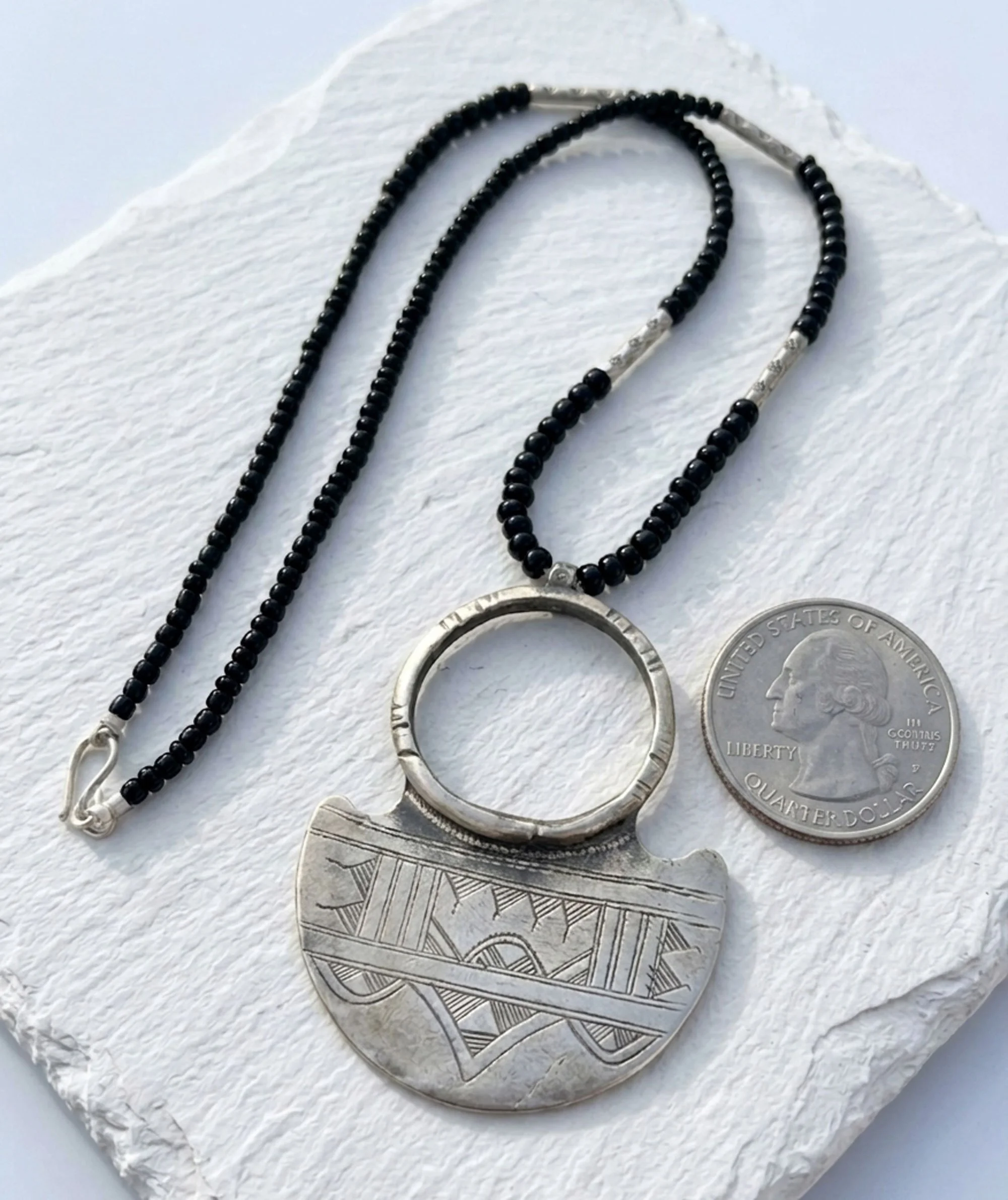 Handcrafted Tuareg-inspired silver necklace with black bead accents, artisan boho statement jewelry.