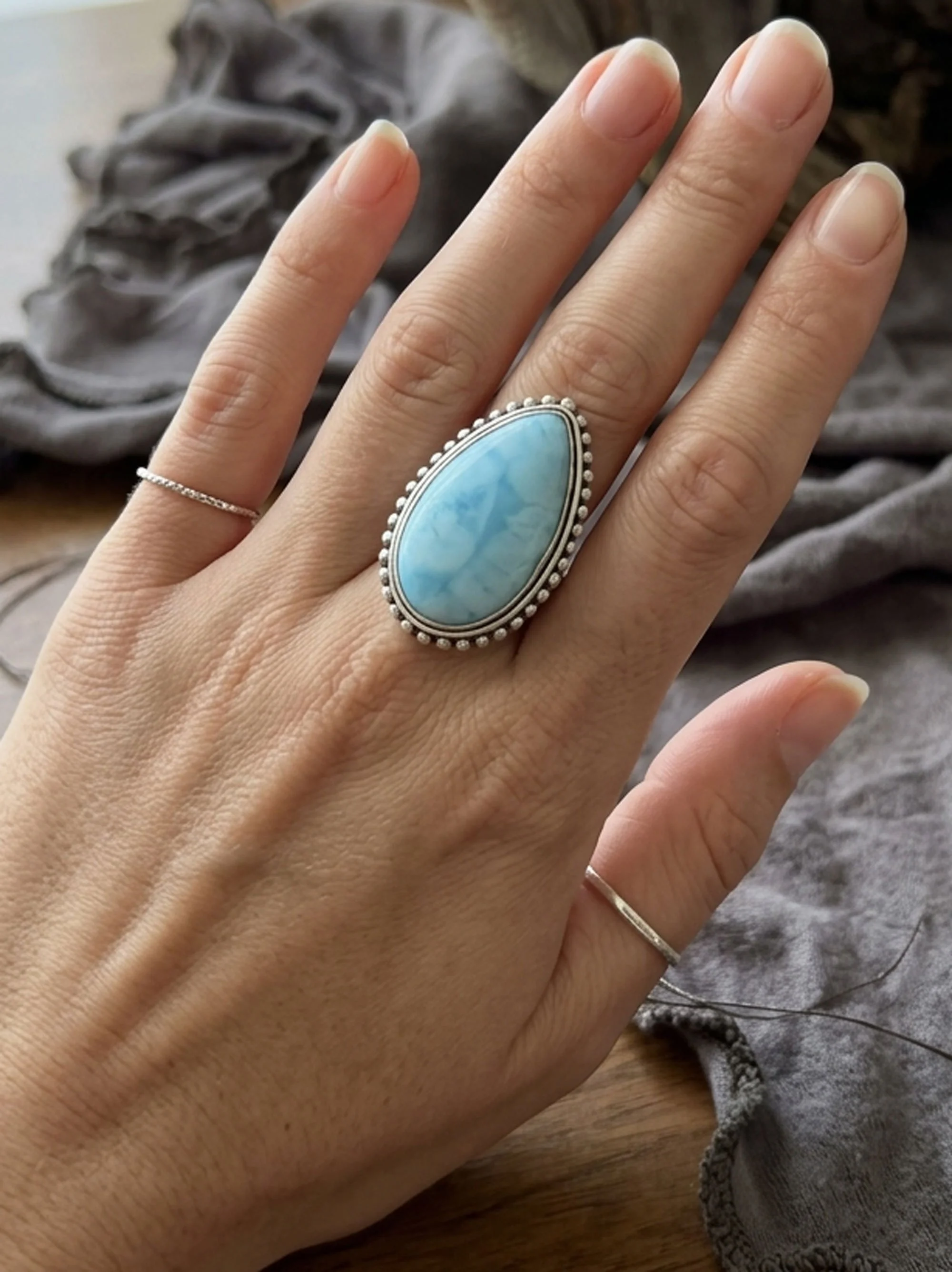 Larimar teardrop statement ring worn on hand with natural light