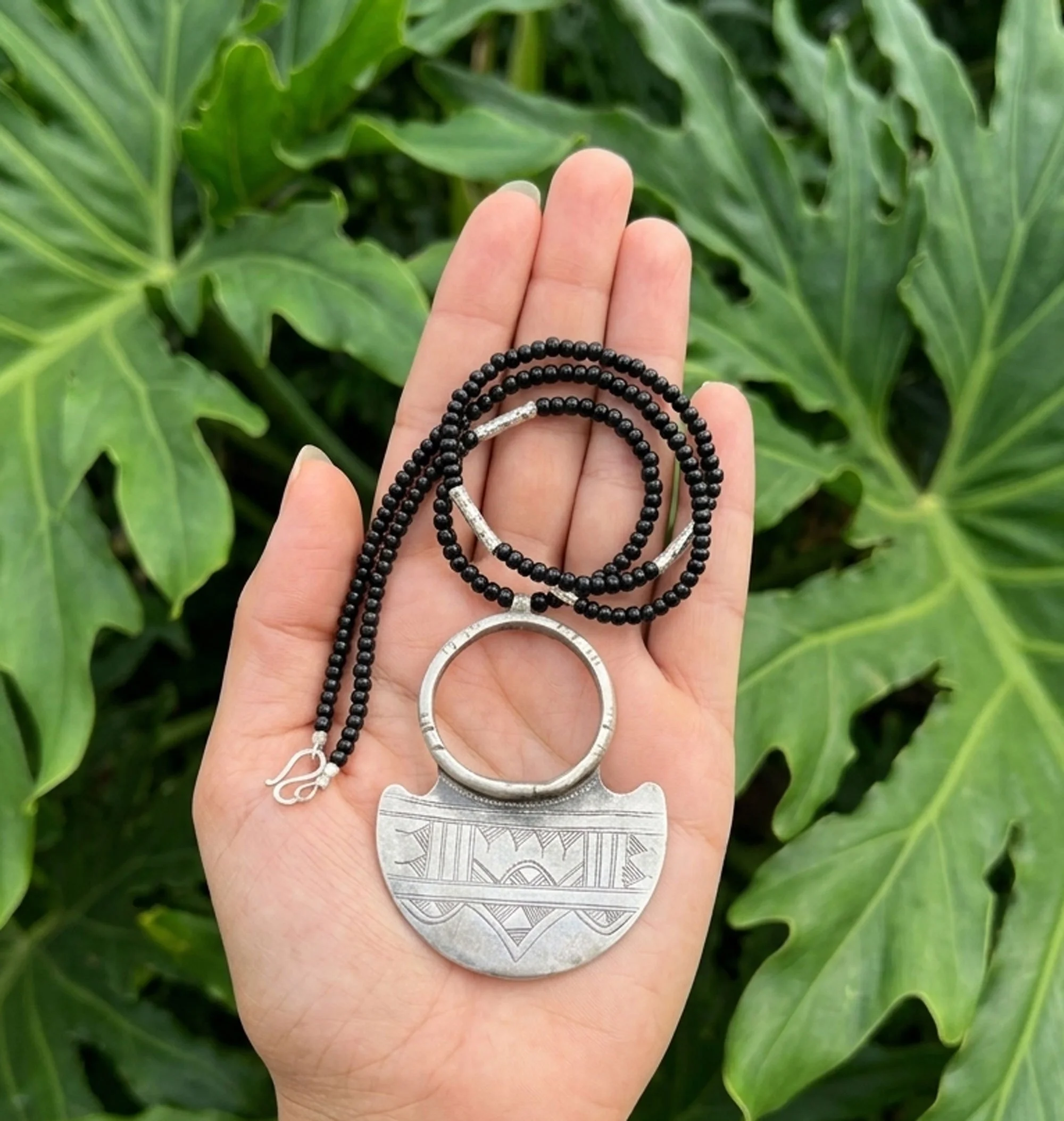 Tuareg-inspired sterling silver pendant necklace with black beads, artisan handcrafted boho jewelry.