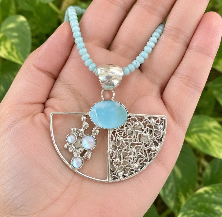 Handmade Larimar and freshwater pearl sterling silver pendant from Bali shown in hand.