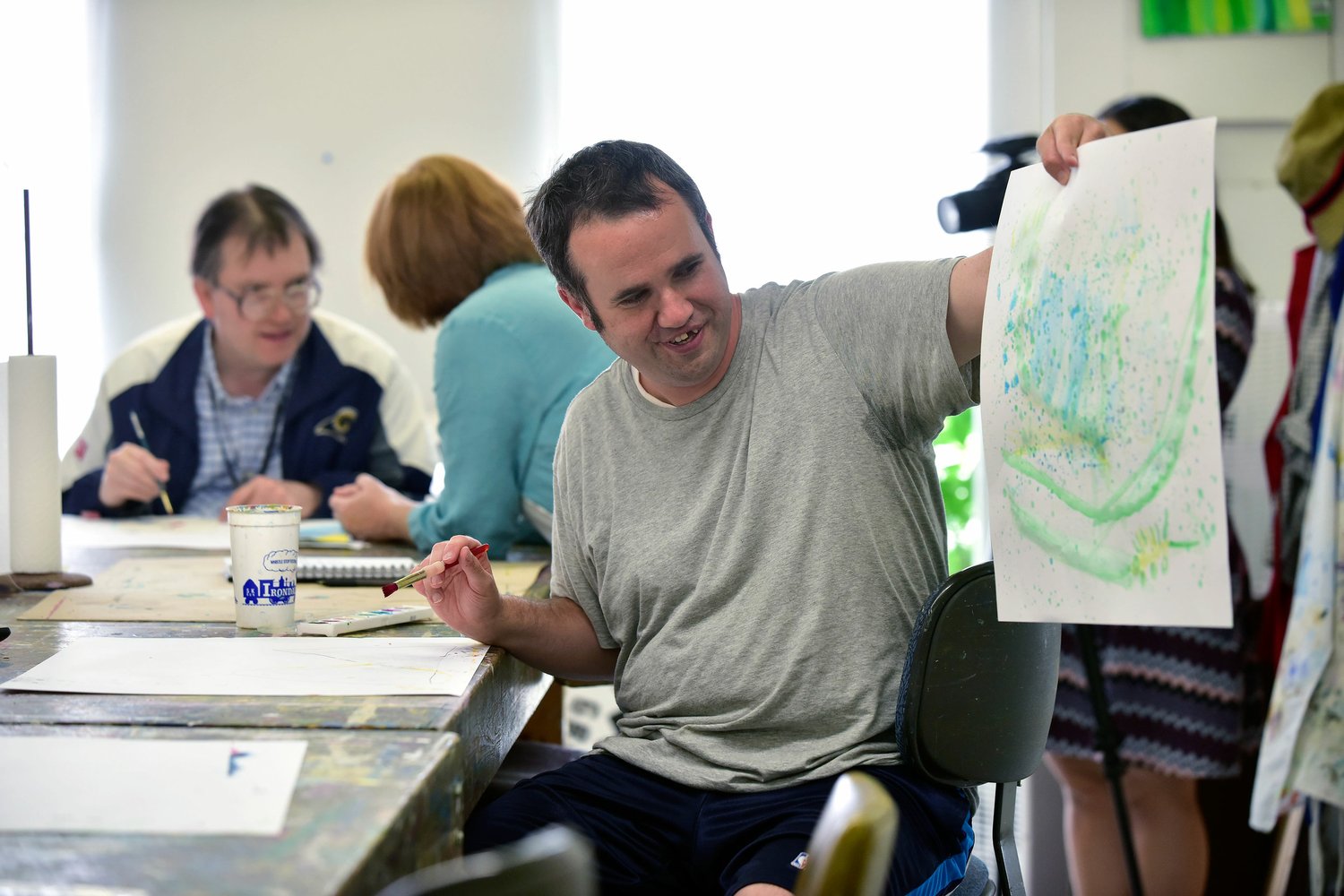Austin proudly displays his work with watercolors. Photo by Frank Couch.