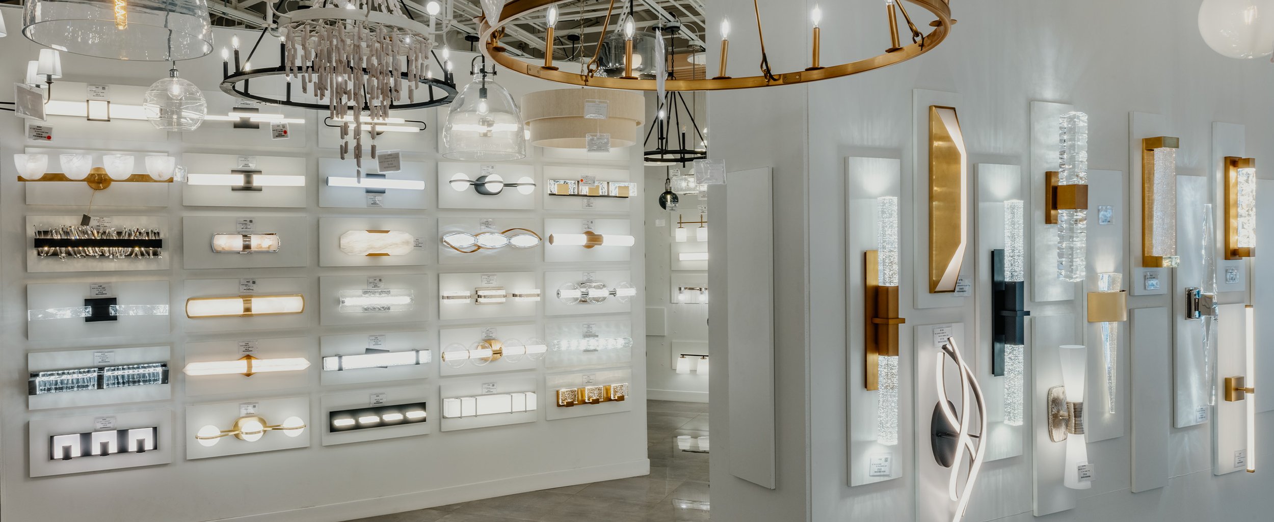 Lighting display with various modern wall and ceiling light fixtures in a showroom.