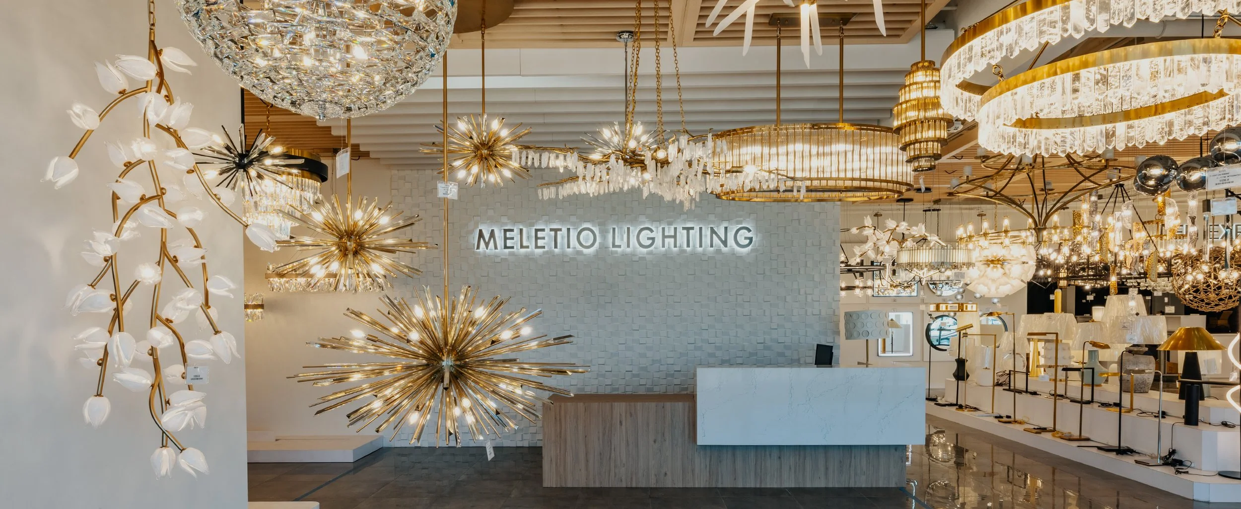Lighting store display with various chandeliers and fixtures, and a sign that reads 'Meletio Lighting'.