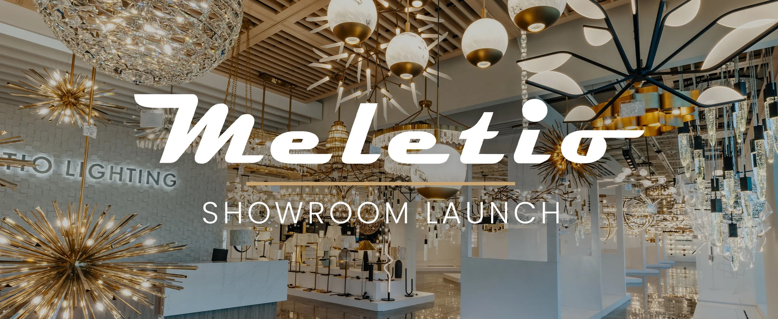 Interior of a lighting showroom with modern and decorative chandeliers and light fixtures, signage that says 'Meletio Showroom Launch'.