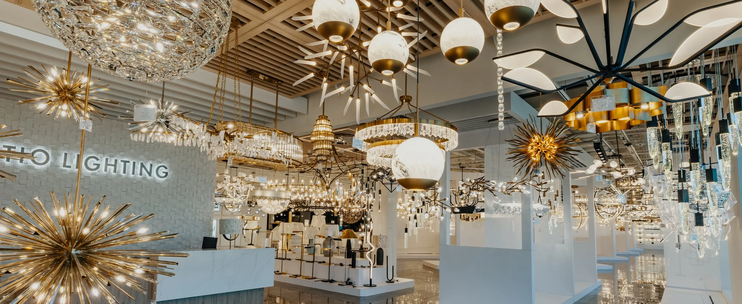 A showroom filled with various modern and chandelier-style ceiling lights and fixtures on display.