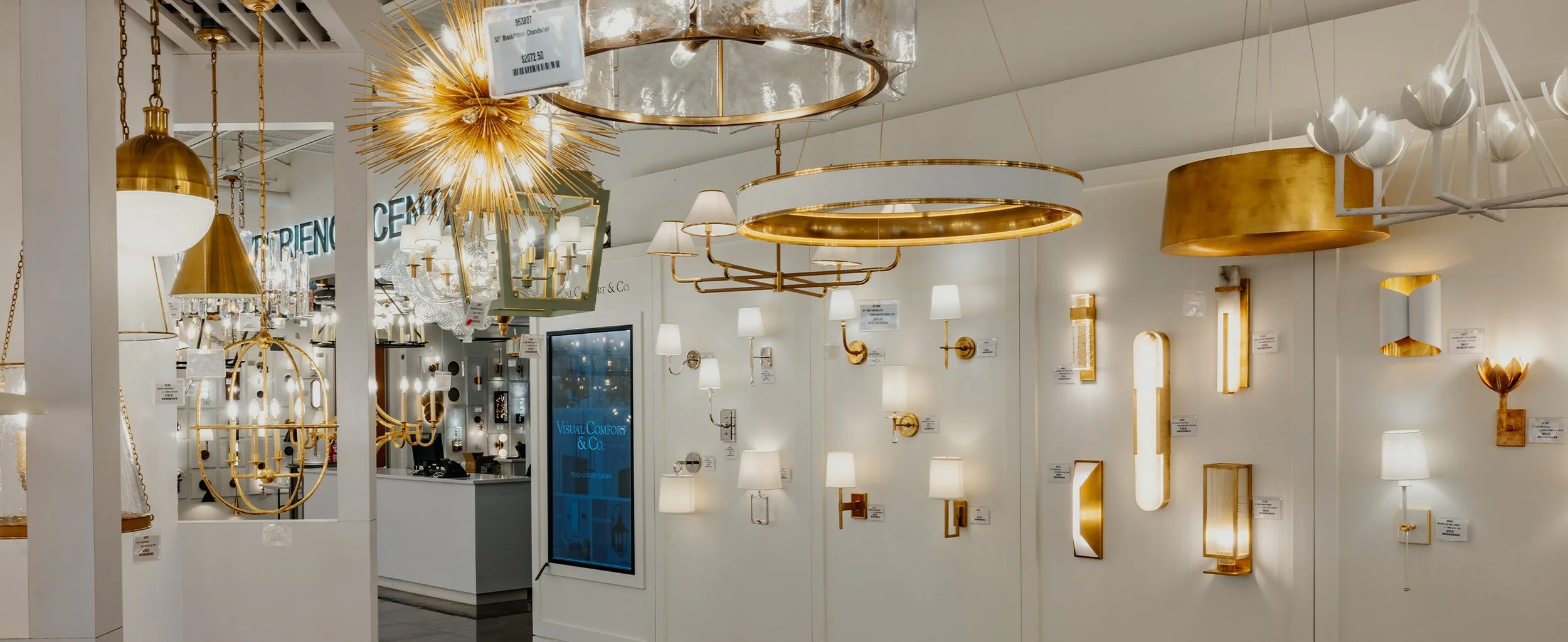 A display of various modern and decorative ceiling lights and wall sconces in a lighting store.