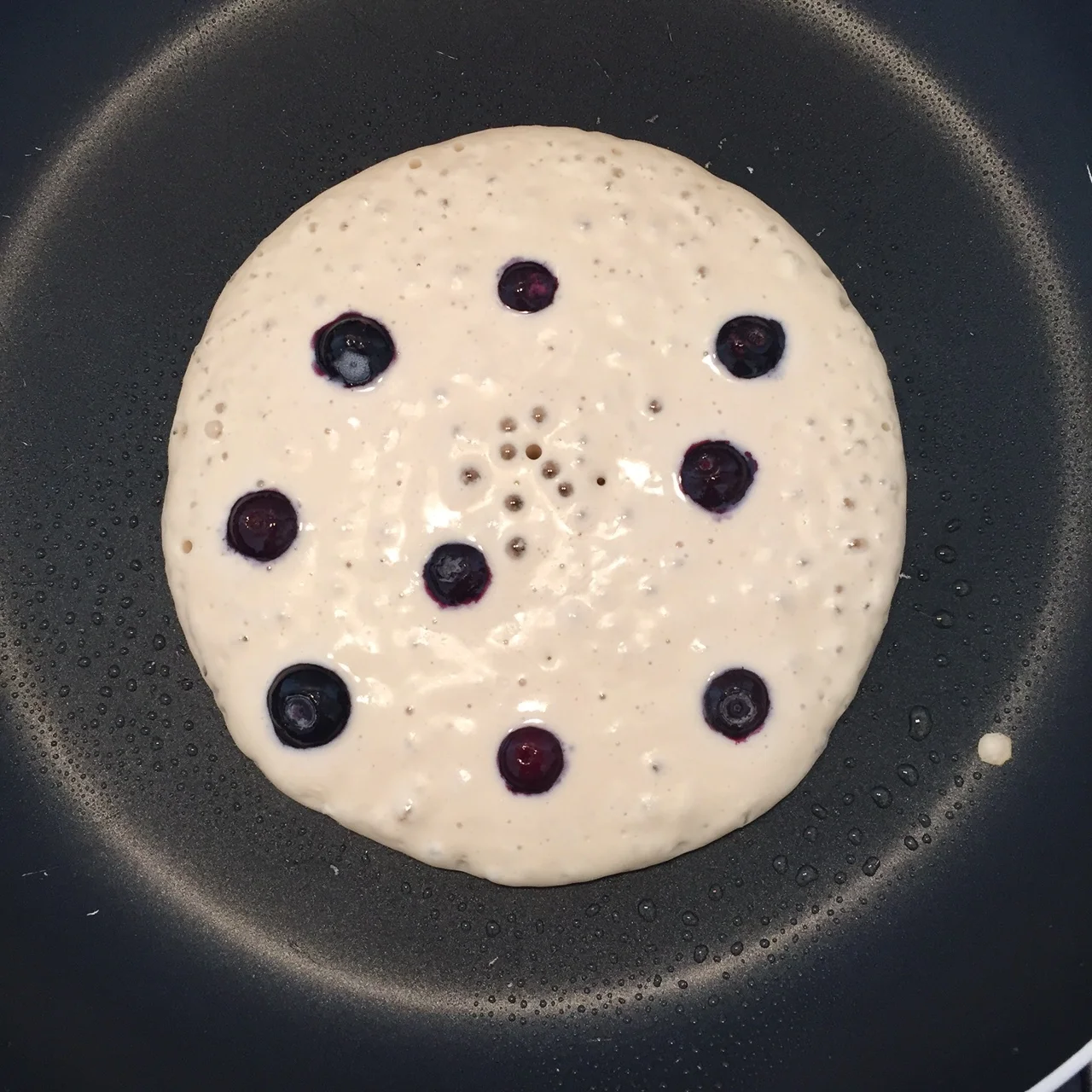 Pancake cooking in pan. Ready to flip