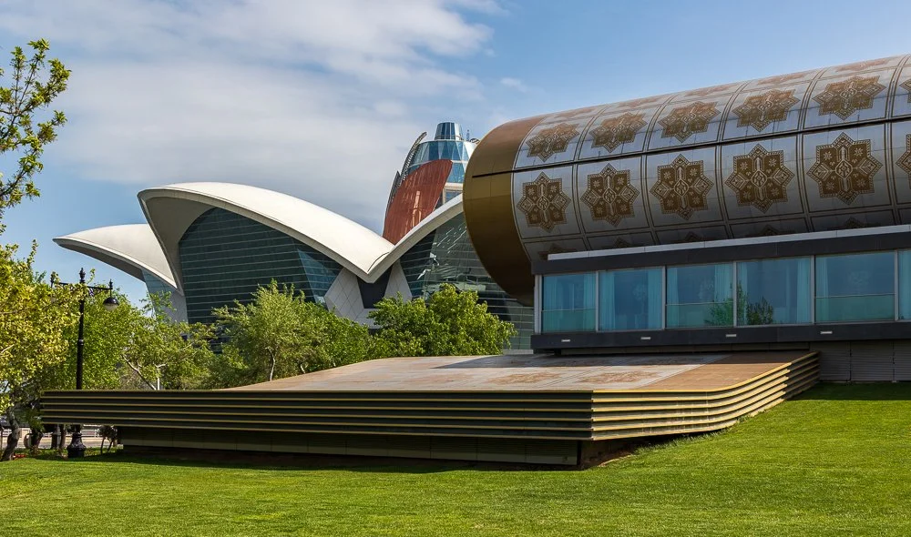   Carpet Museum  The building itself is shaped like a rolled carpet, a detail that earns its place rather than undermining it. Inside, over 6,000 Azerbaijani carpets arranged by region and style, some dating to the 1600s. Each one documents a place a