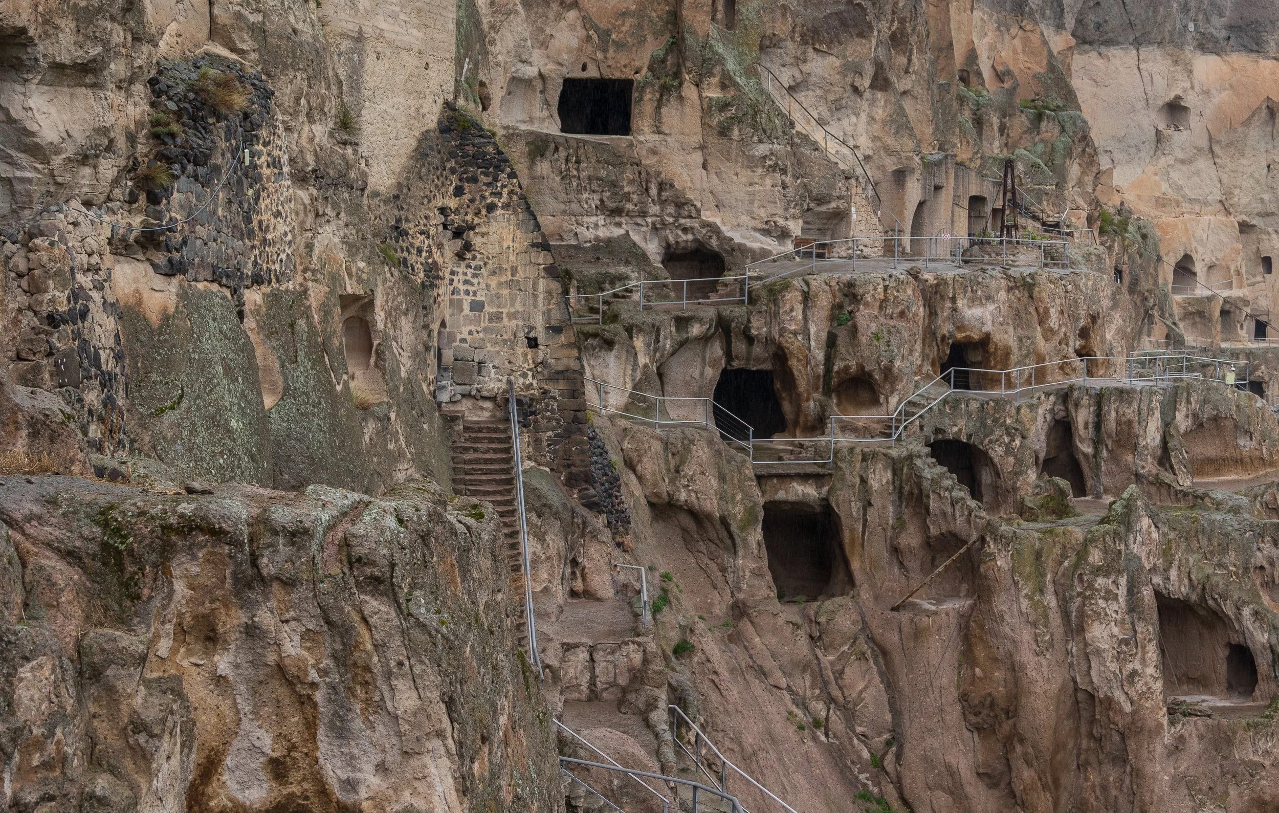  At its peak the complex housed some 2,000 monks across 19 levels. An earthquake in 1283 sheared away half the cliff. Ottoman invasions burned the manuscripts. Shepherds moved in after that, which is why many of the chambers are still blackened insid