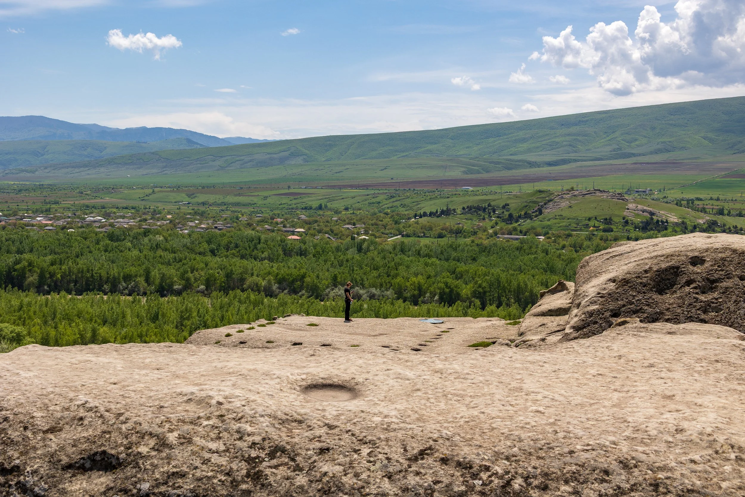  Views looking down and out from the ancient rock-hewn caves of Uplistsikhe, Georgia, feature sweeping, panoramic vistas of the winding Mtkvari River basin and the sprawling rural valleys.  