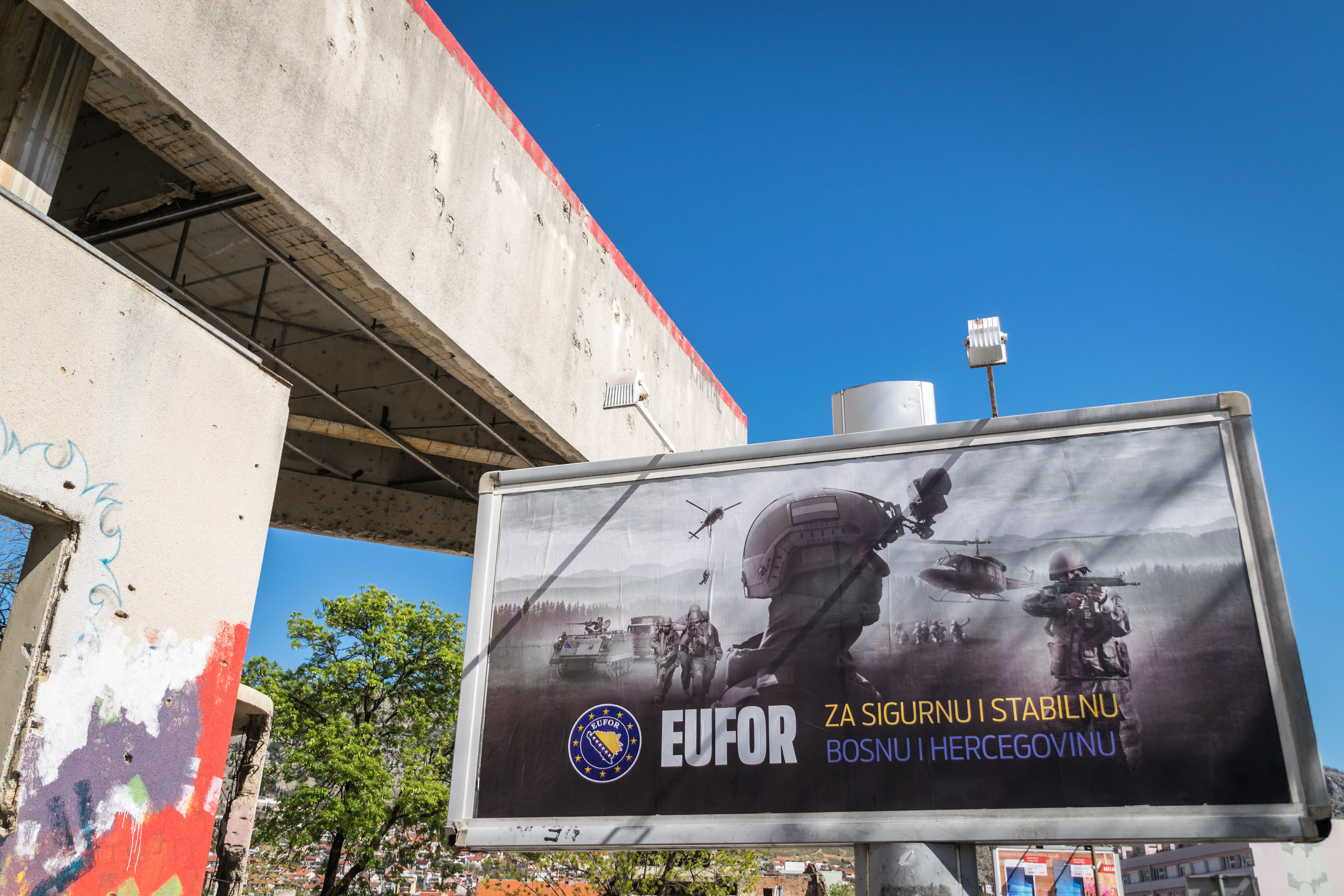 Sign outside of the Sniper Tower: "For a secure and stable Bosnia and Herzegovina" reads the sign selling EUFOR Althea , a military deployment that oversees the implementation of the Dayton Agreement; just my humble opinion, I don't think more guns and fighting will stabilize this war-torn community