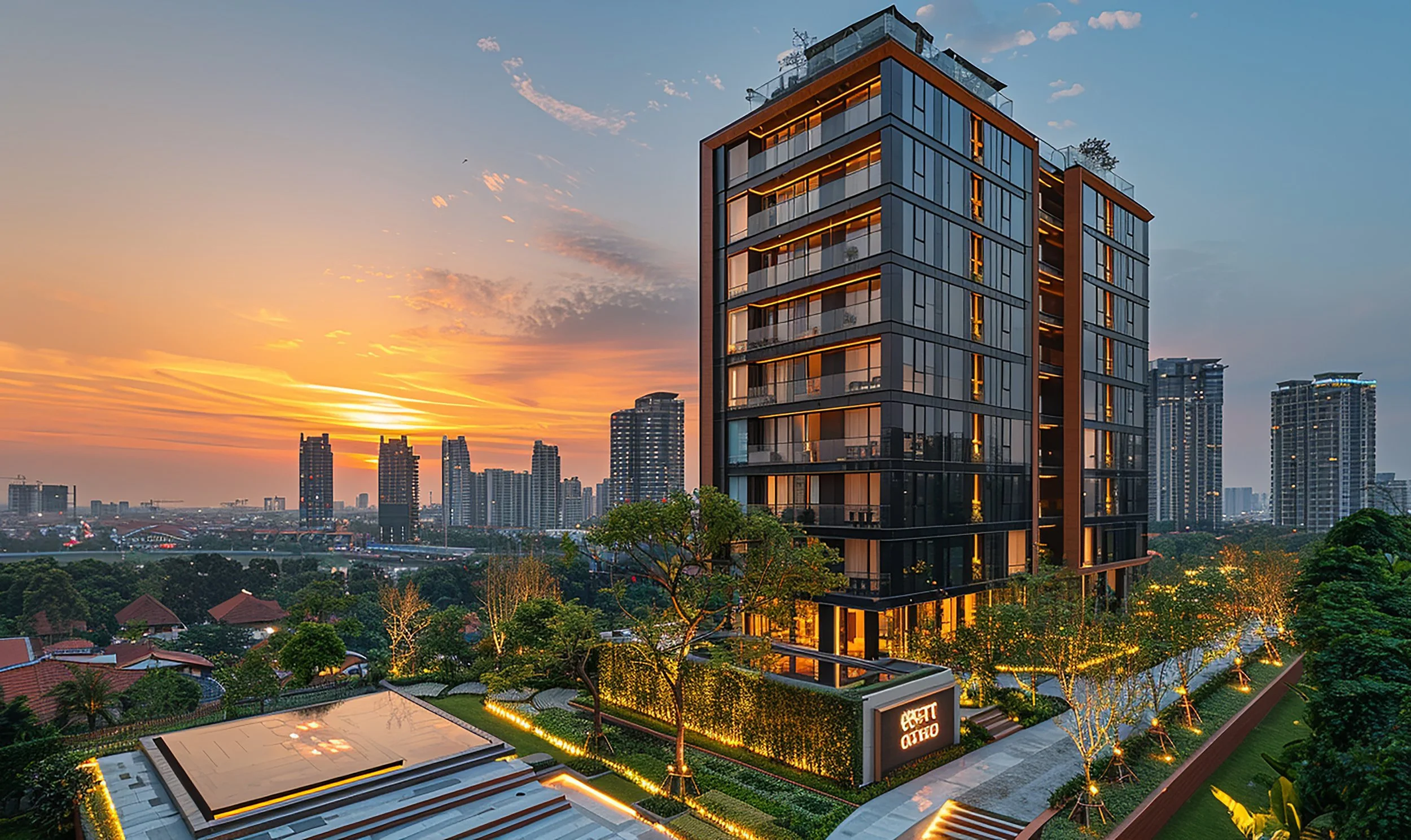 Modern high-rise building with glass facade at sunset, surrounded by trees and city skyline