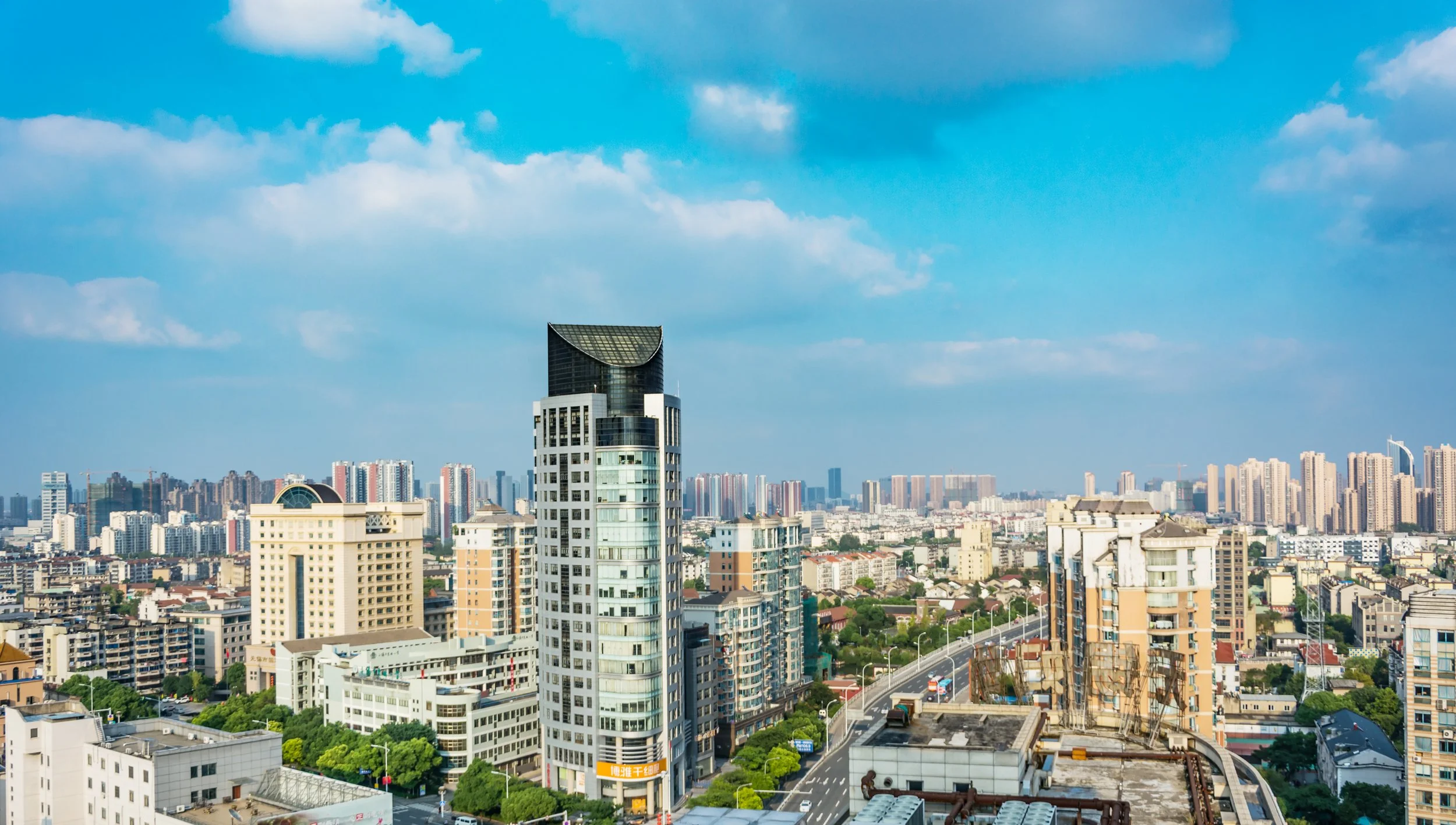 City skyline with tall modern buildings under a partly cloudy sky