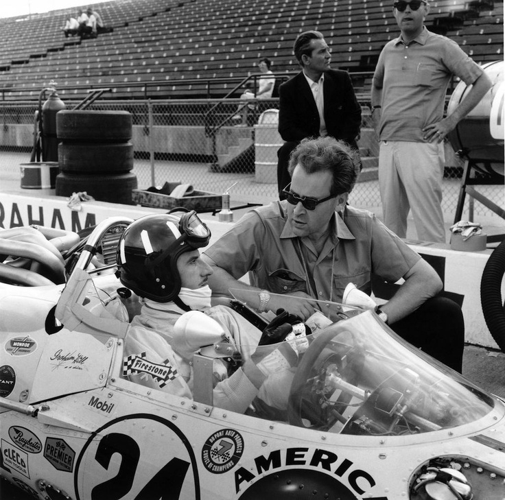 Eric Broadley and Graham Hill sharing a moment in the pits.