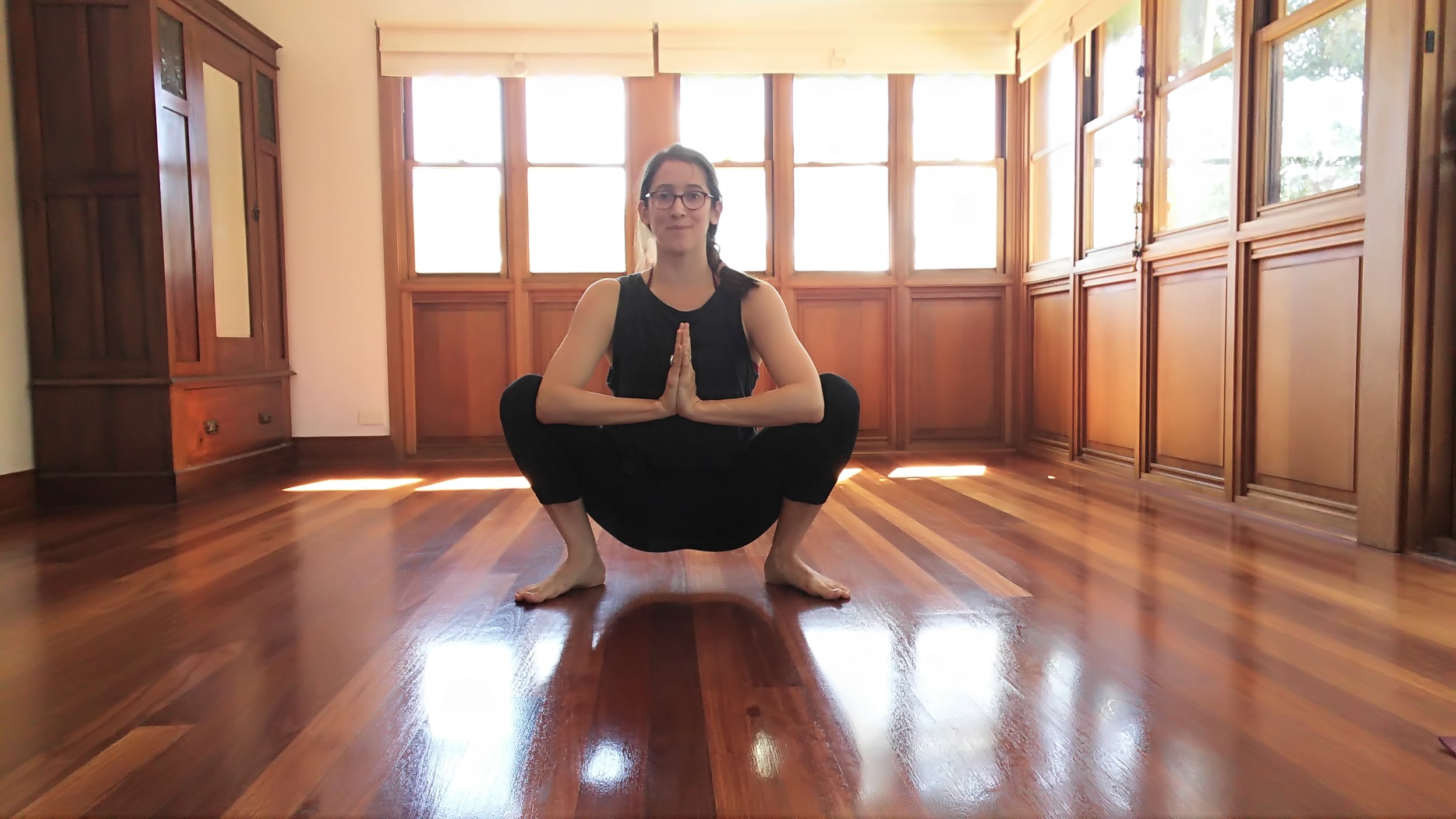  Squat. Push elbows into inner thighs. Bring hands into prayer pose. Elongate the spine straight as much as possible. Beginners can use a block under the buttocks for support. 