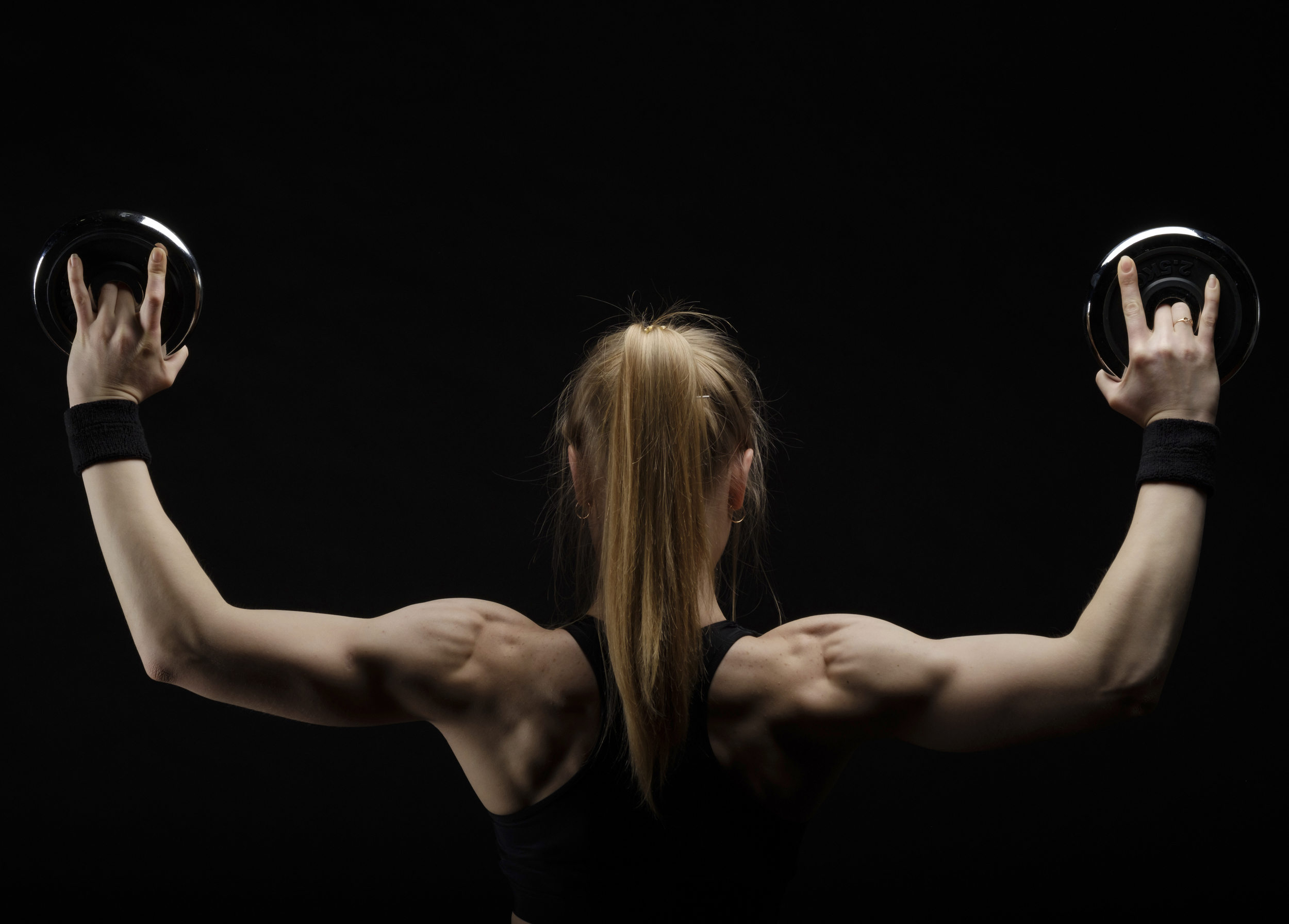 Young-slim-strong-muscular-woman-posing-in-studio-with-dumbbell-000094515321_Full.jpg