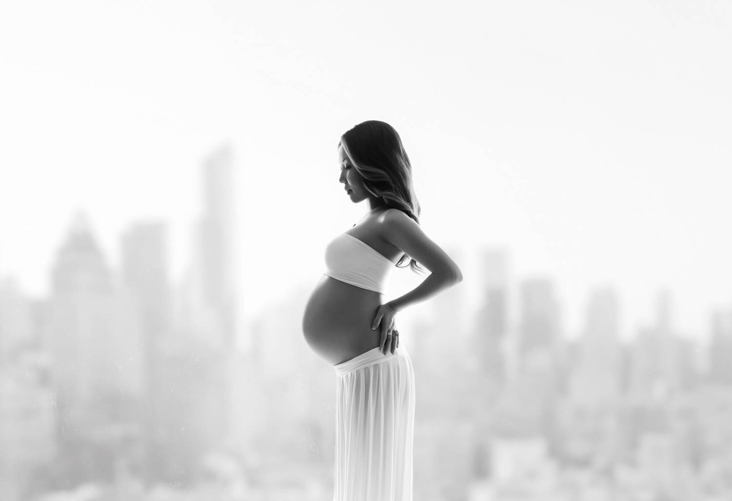 backlit portrait of pregnancy with the NYC skyline view&nbsp; 