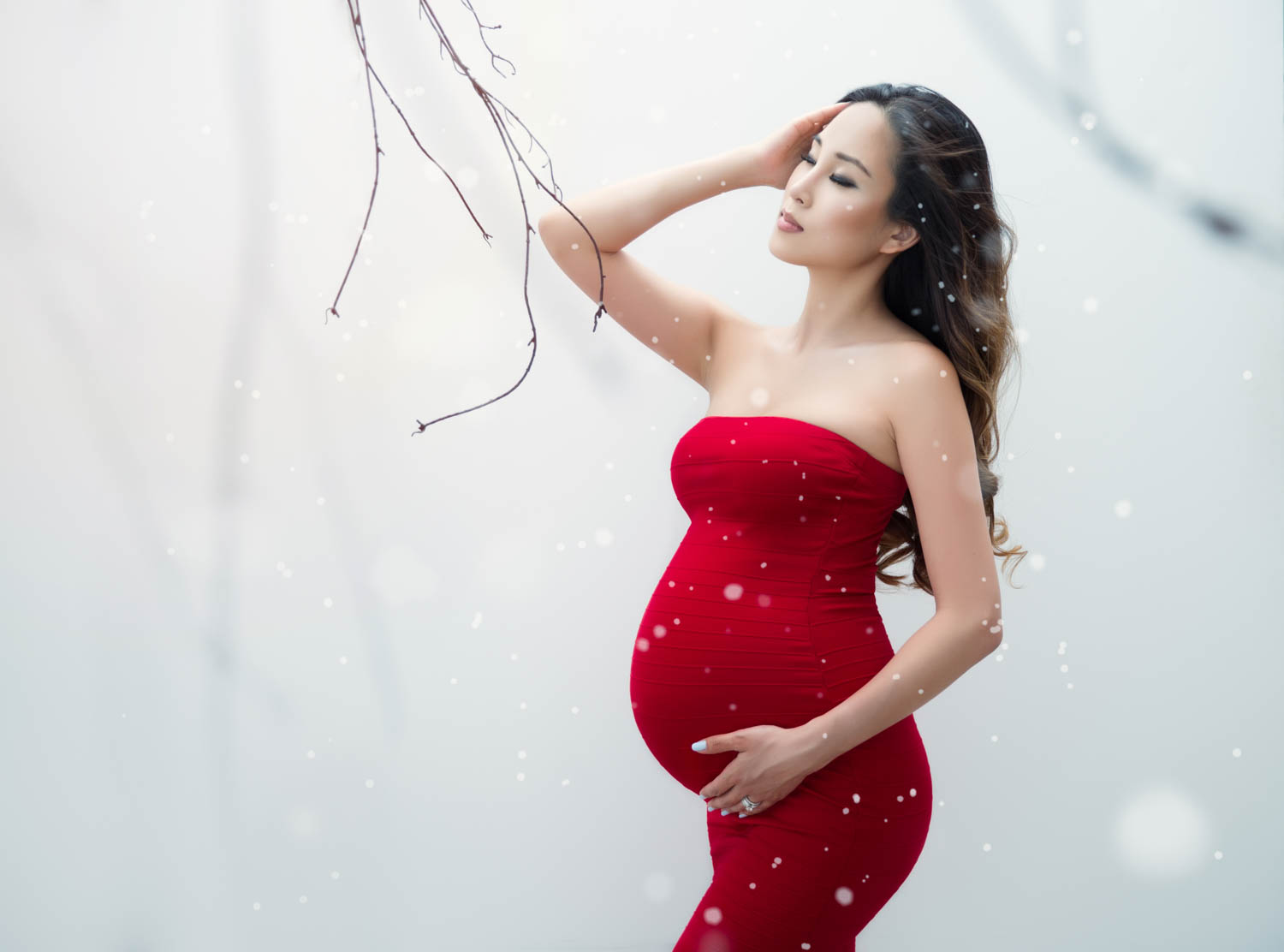red gown and winter scene creates a beautiful contrast for a maternity portrait
