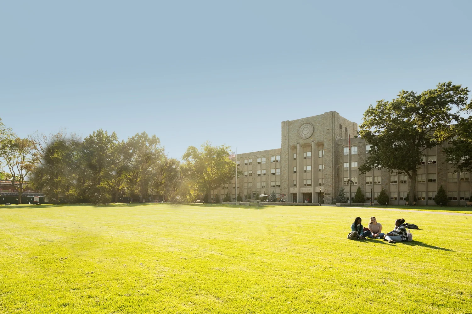College students talking on a campus lawn