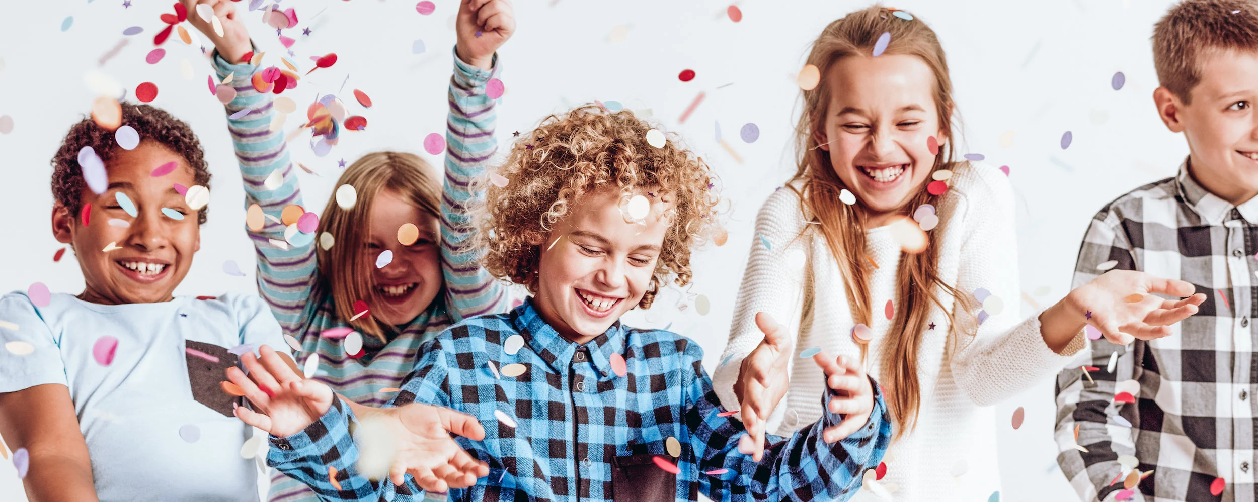 Smiling kids playing with confetti