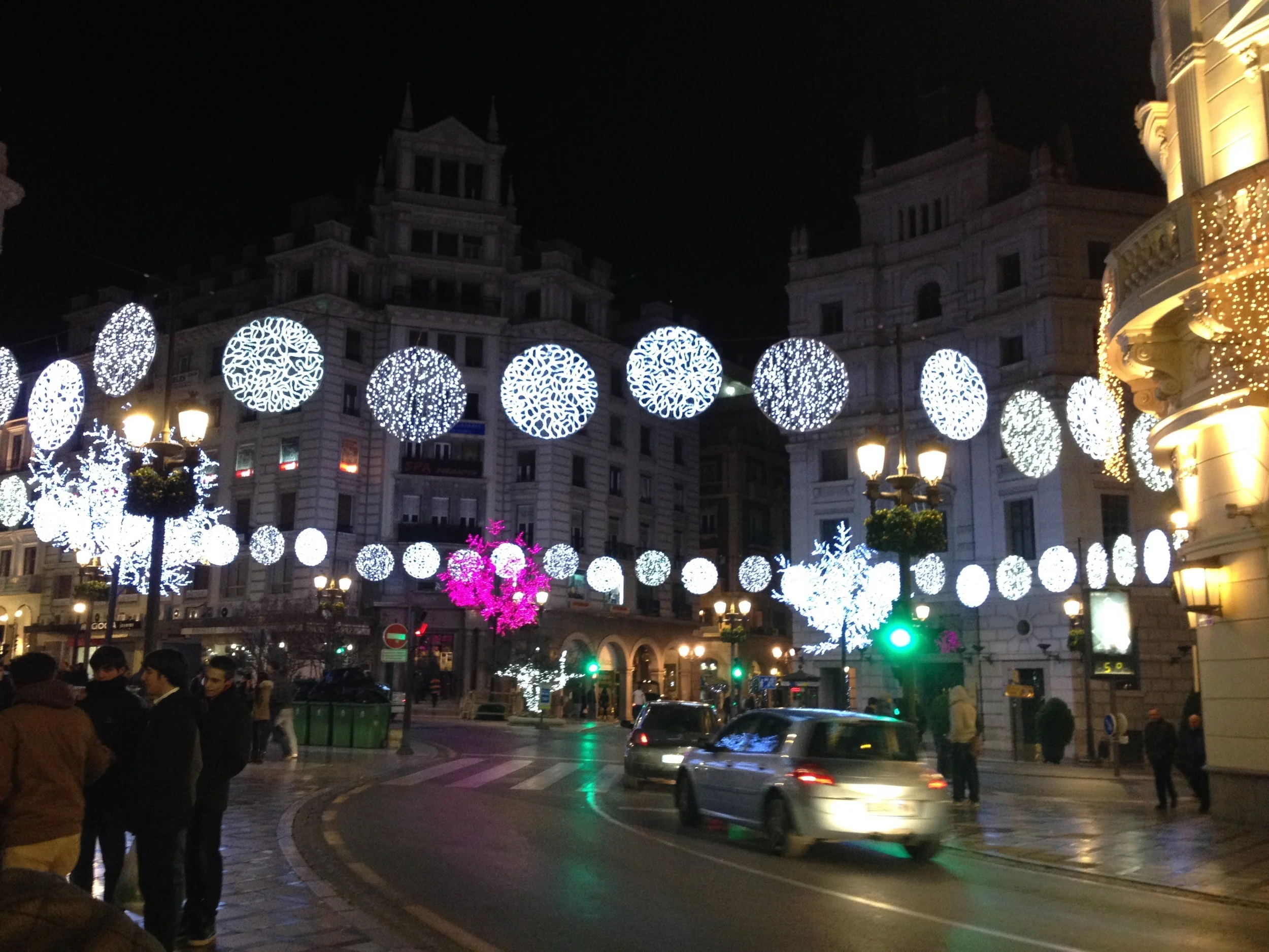 The center of the city, right where Calle Recogidas and C alle Reyes Católicos meet, all dolled up with lights for La Navidad .