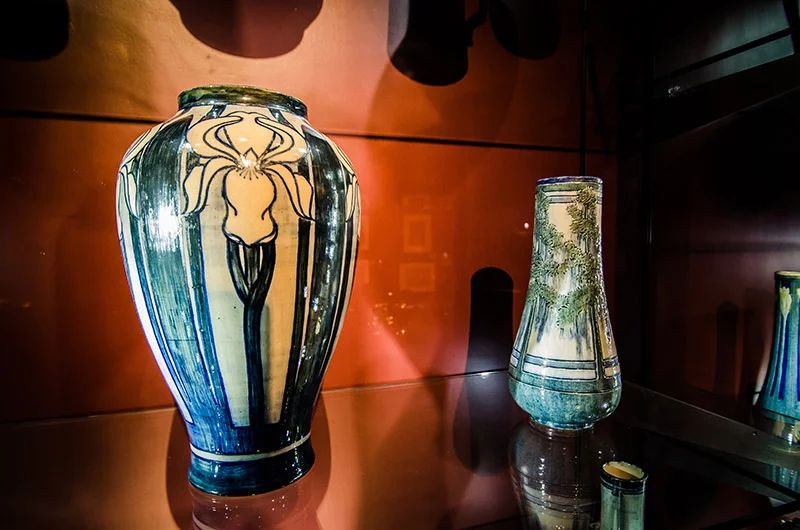 LEFT: Irene Borden Keep (American, b. 1876), Iris Vase , 1904, high glaze on buff clay pottery, Gift of the Friends of LSU Museum of Art, LSUMOA 84.14