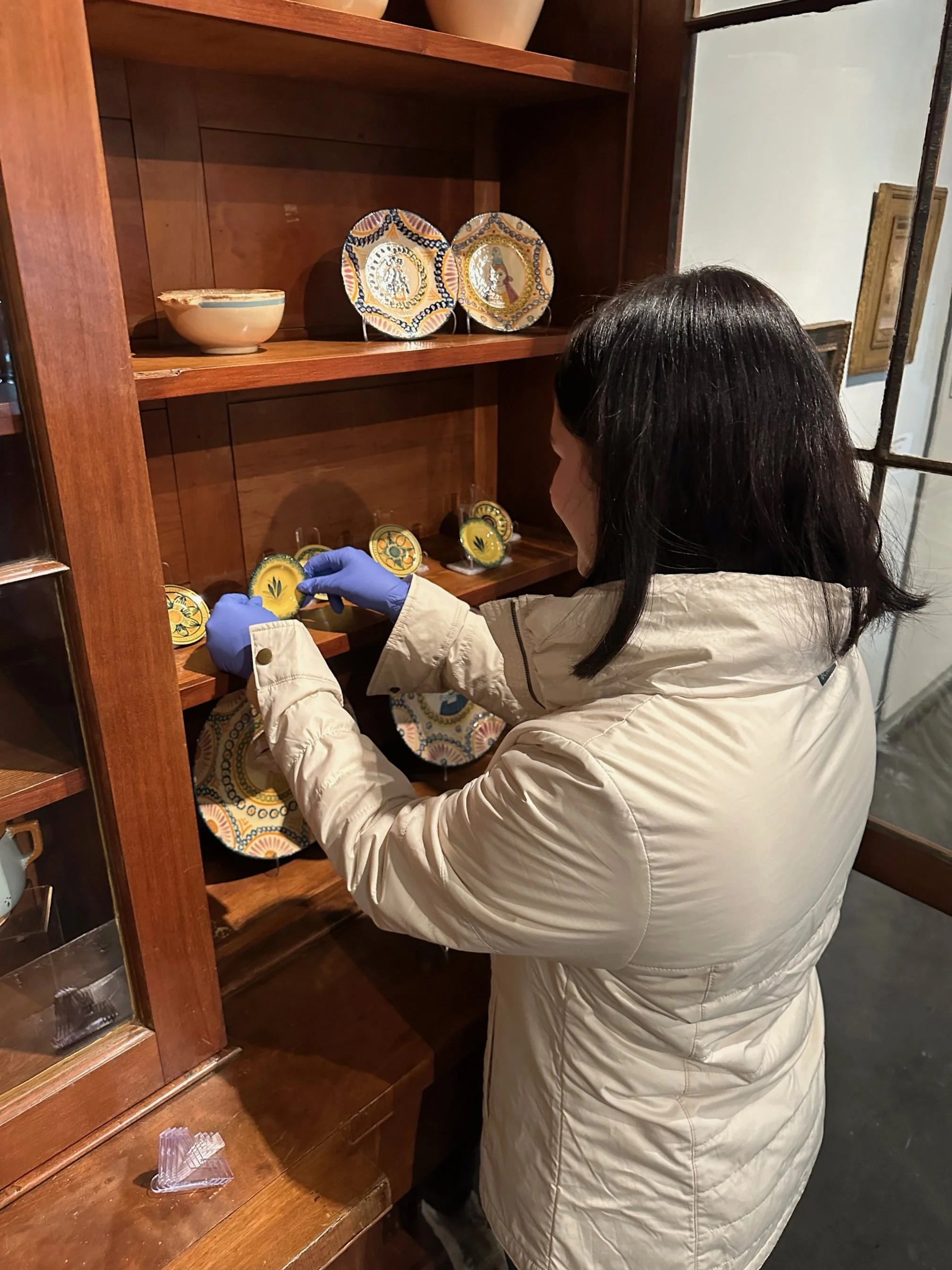  Sarah Ducote, Curatorial Graduate Assistant, installing Quimper Pottery at the LSU Museum of Art. 