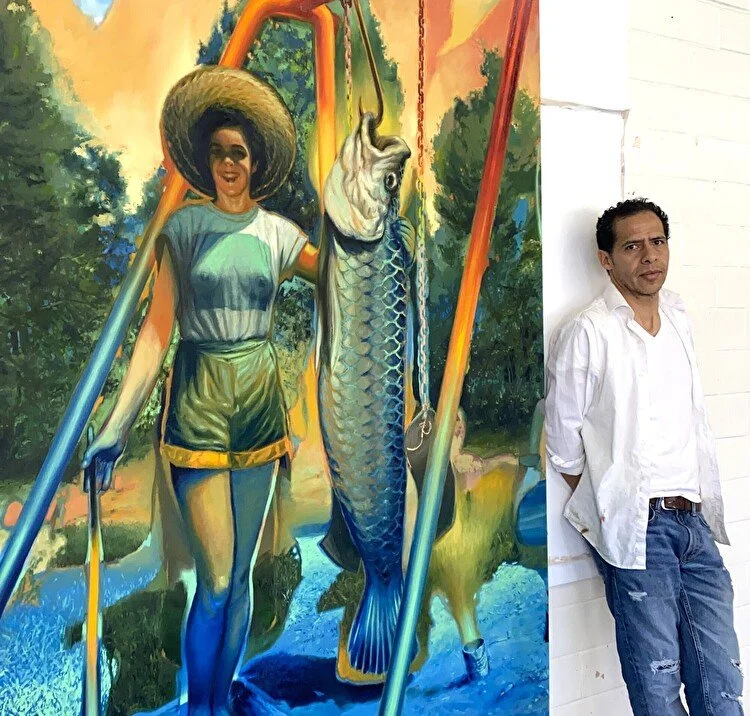 Edgar Canon standing next to one of his paintings in his studio.