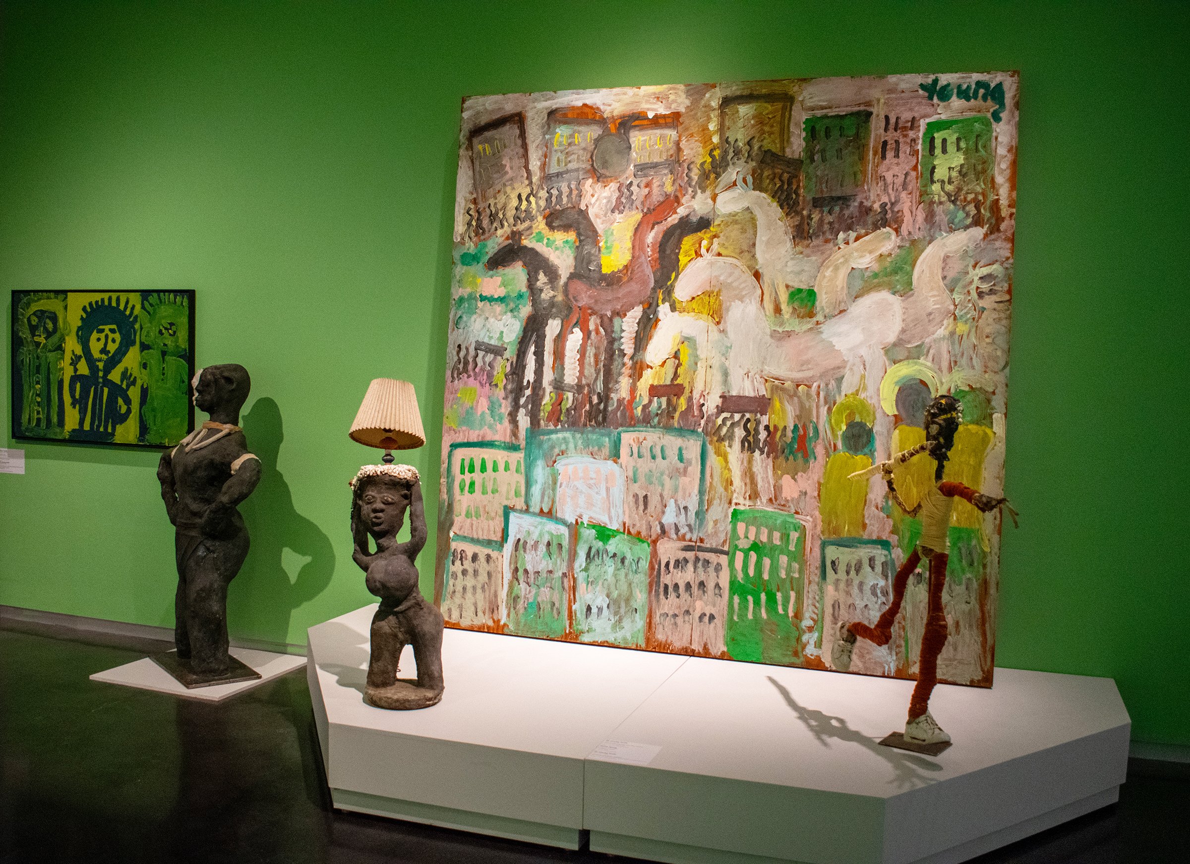 Gallery view of the Folk Art Gallery at the LSU Museum of Art. (left to right) This view features an artwork by Mary T. Smith, sculptures by Dr. Charles Smith, and a large piece by Purvis Young.