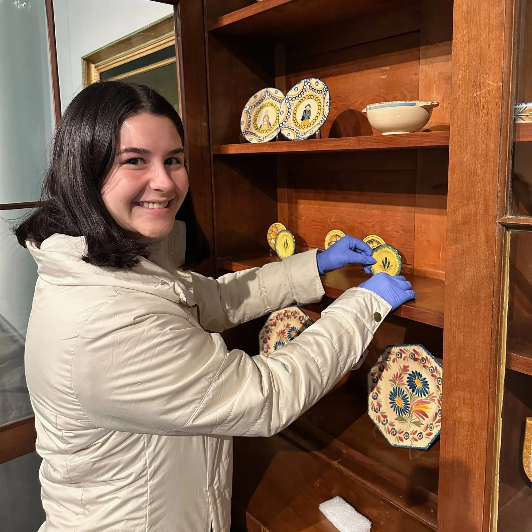 Sarah Ducote, Curatorial Graduate Assistant, installing Quimper Pottery at the LSU Museum of Art.