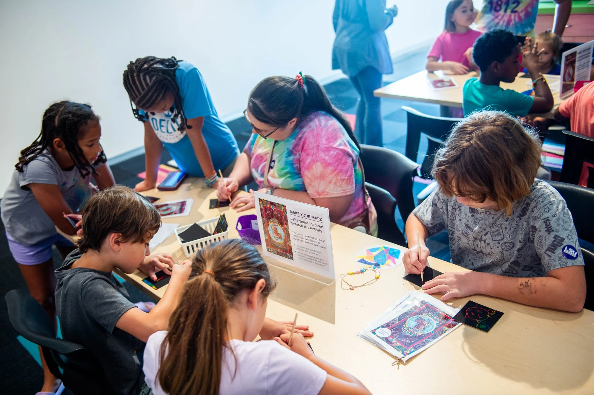 Children sit and draw at a table in the Pennington Family Foundation Education Gallery at the LSU Museum of Art.