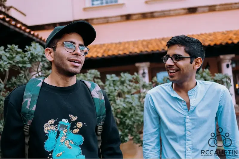 two men walking outdoors together smiling