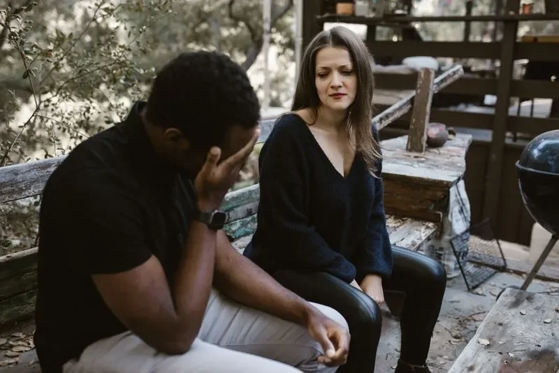 man with head in hands and woman crying