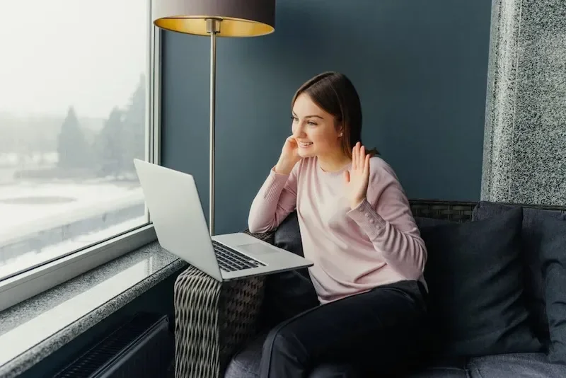 woman on video call smiling at laptop