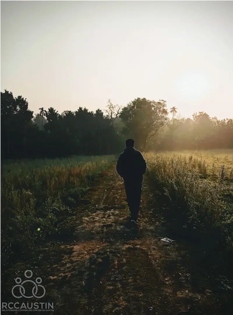 person walking outdoors on trail in morning light