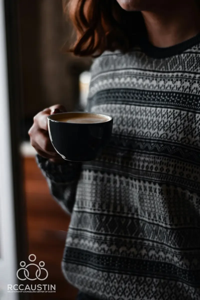 woman in knitted sweater holding coffee