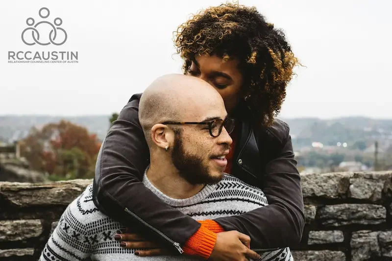 couple embracing outdoors by stone wall