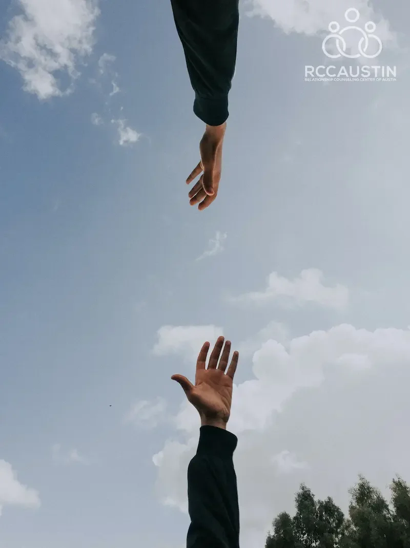 two hands reaching out across blue sky