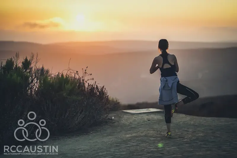 woman doing yoga tree pose at sunrise