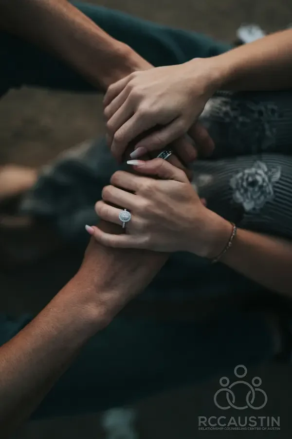 woman wearing engagement ring holding partners hands