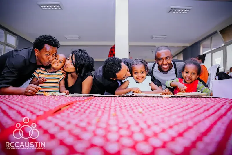 family sitting around table smiling