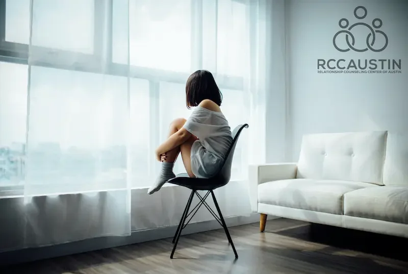 woman sat on chair looking out of window