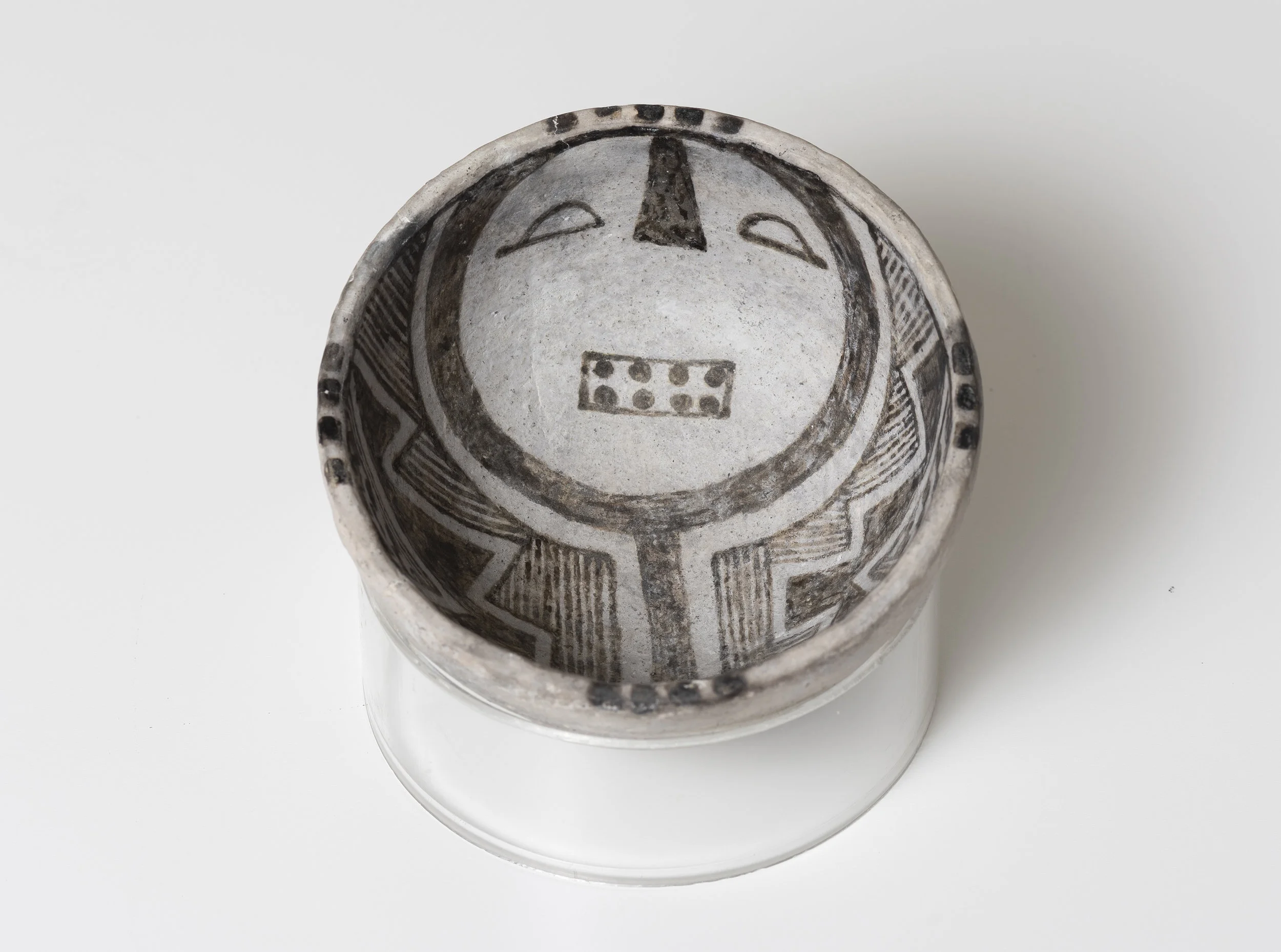 Snowflake Black-on-White Humanoid face c. 1175 - 1325 CE Painted ceramic 3.75 inches diameter, 2 inches depth